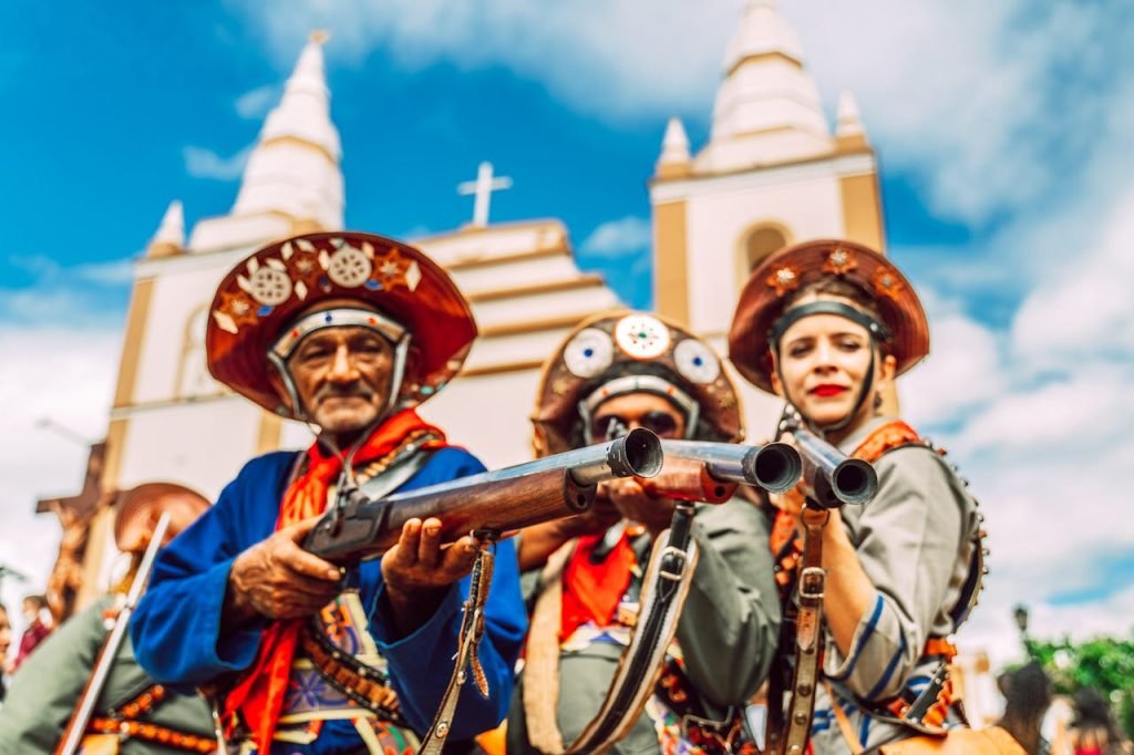 Colorful cultural parade featuring performers in traditional costumes in front of a historic church.
