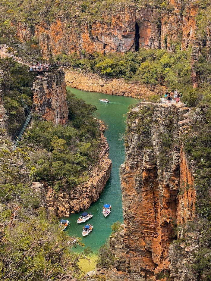 Aerial shot of a vibrant canyon with boats and lush greenery, showcasing natures beauty.